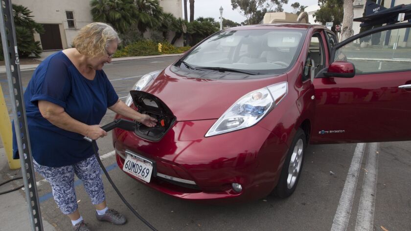 Diane Gordon connects her Nissan Leaf to a charging station in Balboa Park in July 2018.