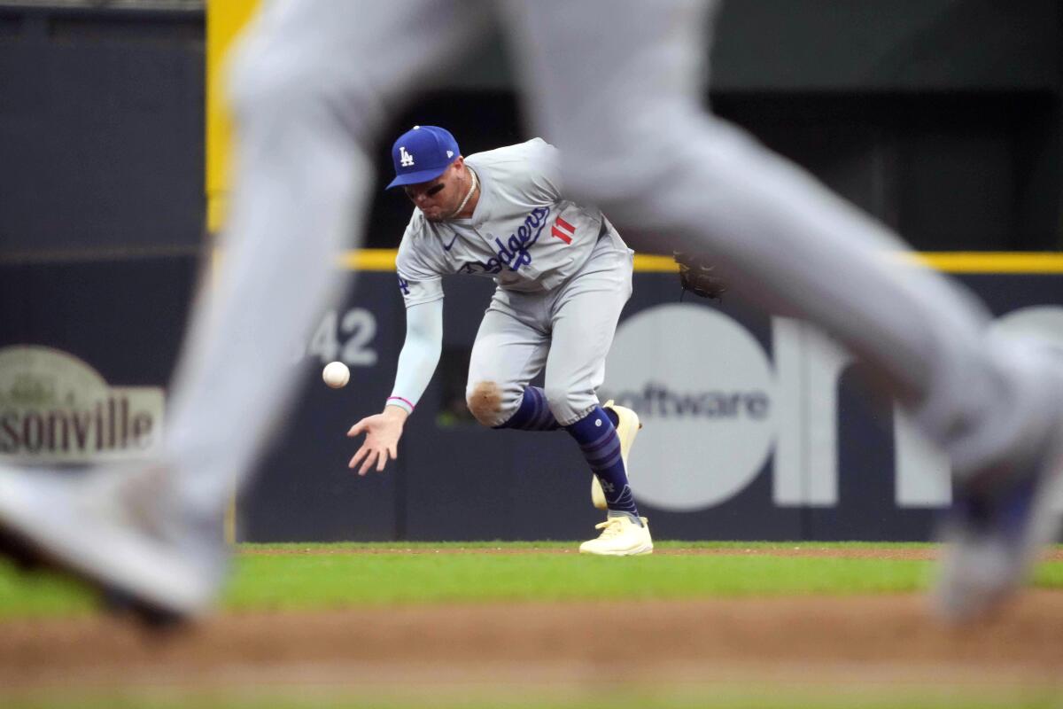 Dodgers shortstop Miguel Rojas reaches for a ball 