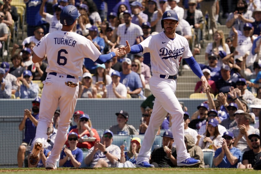 Los Angeles Dodgers' Trea Turner, left, and Freddie Freeman congratulate each other after they scored on a double by Max Muncy during the fourth inning of a baseball game against the Cincinnati Reds Sunday, April 17, 2022, in Los Angeles. (AP Photo/Mark J. Terrill)