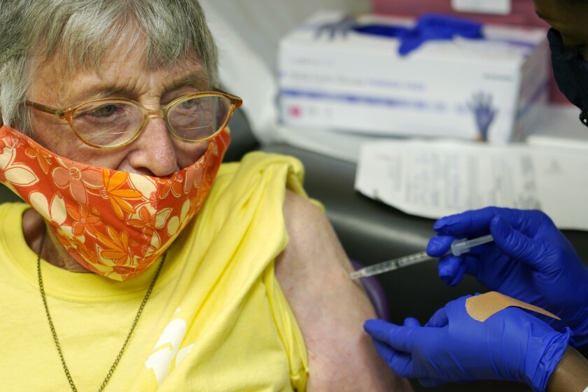 Linda Busby, 74, stiffens up as she receives the Johnson & Johnson COVID-19 vaccine at the Aaron E. Henry Community Health Service Center, Wednesday, April 7, 2021, in Clarksdale, Miss. Busby joined a group of seniors from the Rev. S.L.A. Jones Activity Center for the Elderly that were given a ride to the health center for their vaccinations. The Mississippi Department of Human Services is in the initial stages of teaming up with community senior services statewide to help older residents get vaccinated. (AP Photo/Rogelio V. Solis)