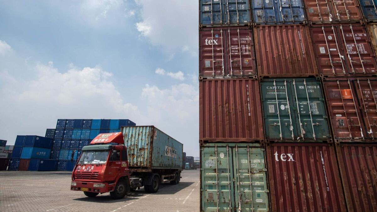A truck carries a shipping container at a port in China's eastern Jiangsu province.
