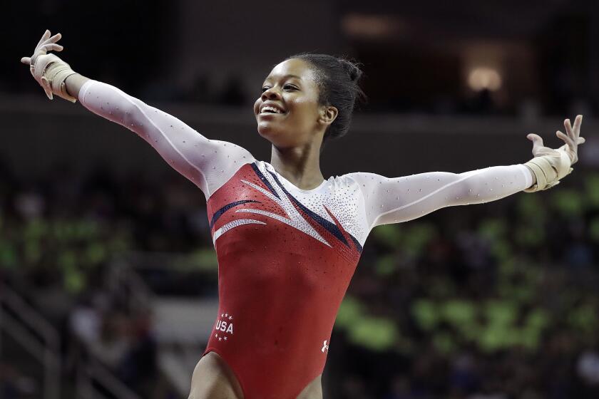 FILE - Gabrielle Douglas smiles after competing on the floor exercise during the women's U.S. Olympic gymnastics.