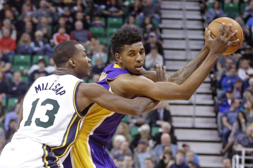 Lakers forward Nick Young keeps the ball away from Jazz defender Elijah Millsap in the first half.