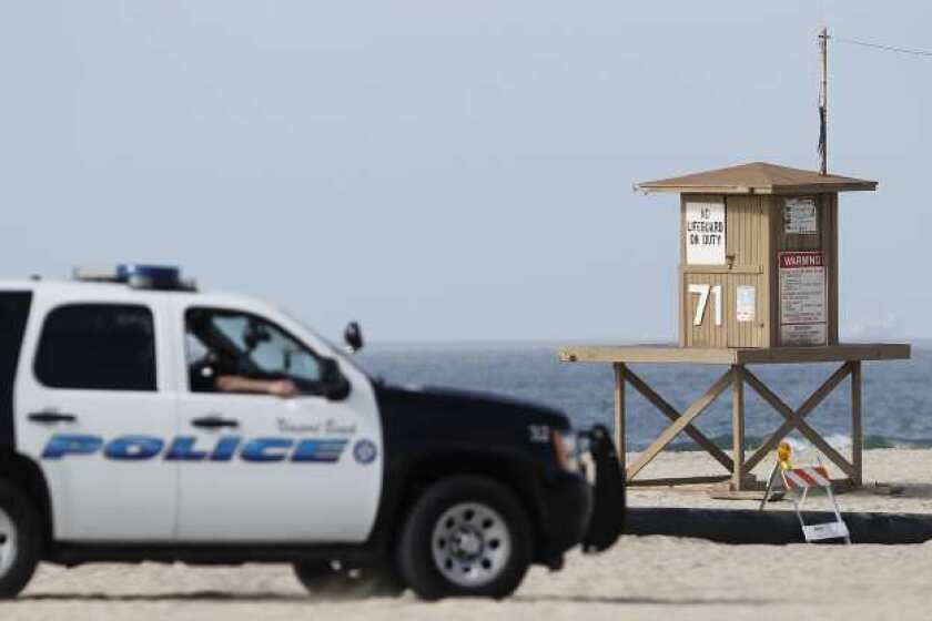 A Newport Beach Police vehicle drives by Tower 71, where a dead body was found on Monday, March 4.