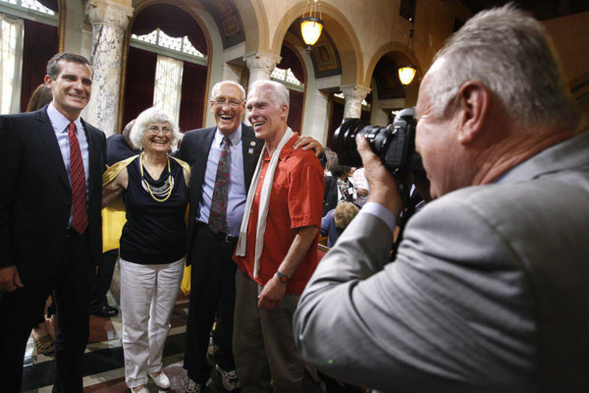 Los Angeles City Councilman Tom LaBonge, right, takes a photograph of Mayor-elect Eric Garcetti, Garcetti's mother Sukey Roth, Councilman Bill Rosendahl and Garcetti's father Gil Garcetti, in City Council chambers on Friday.
