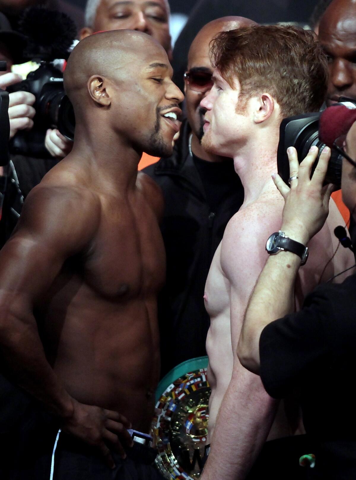 Floyd Mayweather Jr., left, and Saul "Canelo" Alvarez face off during Friday's weigh-in in Las Vegas.