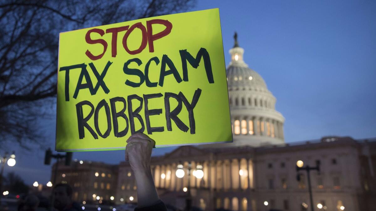 A person participating in a rally holds a sign in protest of a Republican-crafted tax cut plan outside the U.S. Capitol building on Nov. 30.