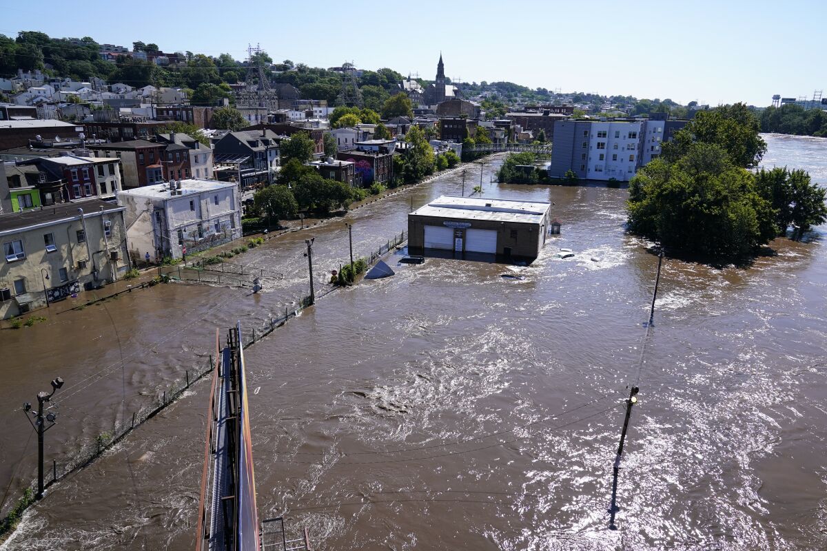 The Schuylkill River exceeds its bank in the Manayunk section of Philadelphia, Thursday, Sept. 2, 2021 in the aftermath of downpours and high winds from the remnants of Hurricane Ida that hit the area. (AP Photo/Matt Rourke)