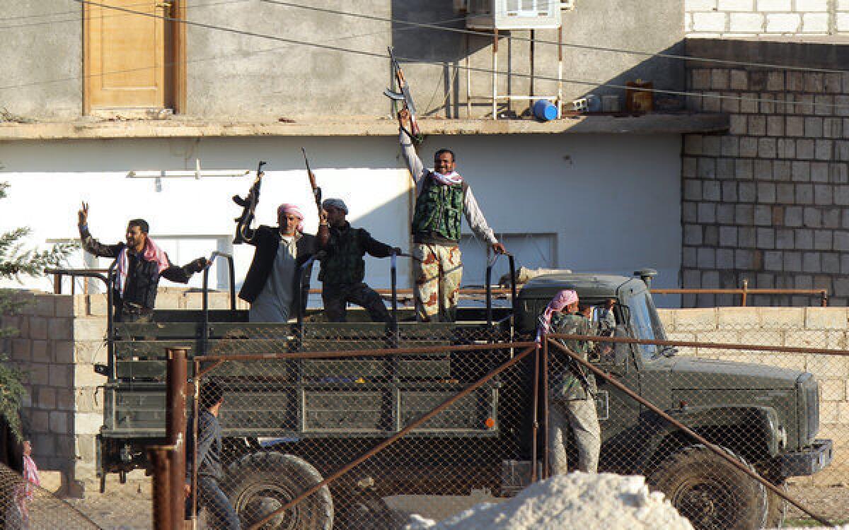 Syrian opposition fighters celebrate on the strategic Syrian border town of Ras Ayn.