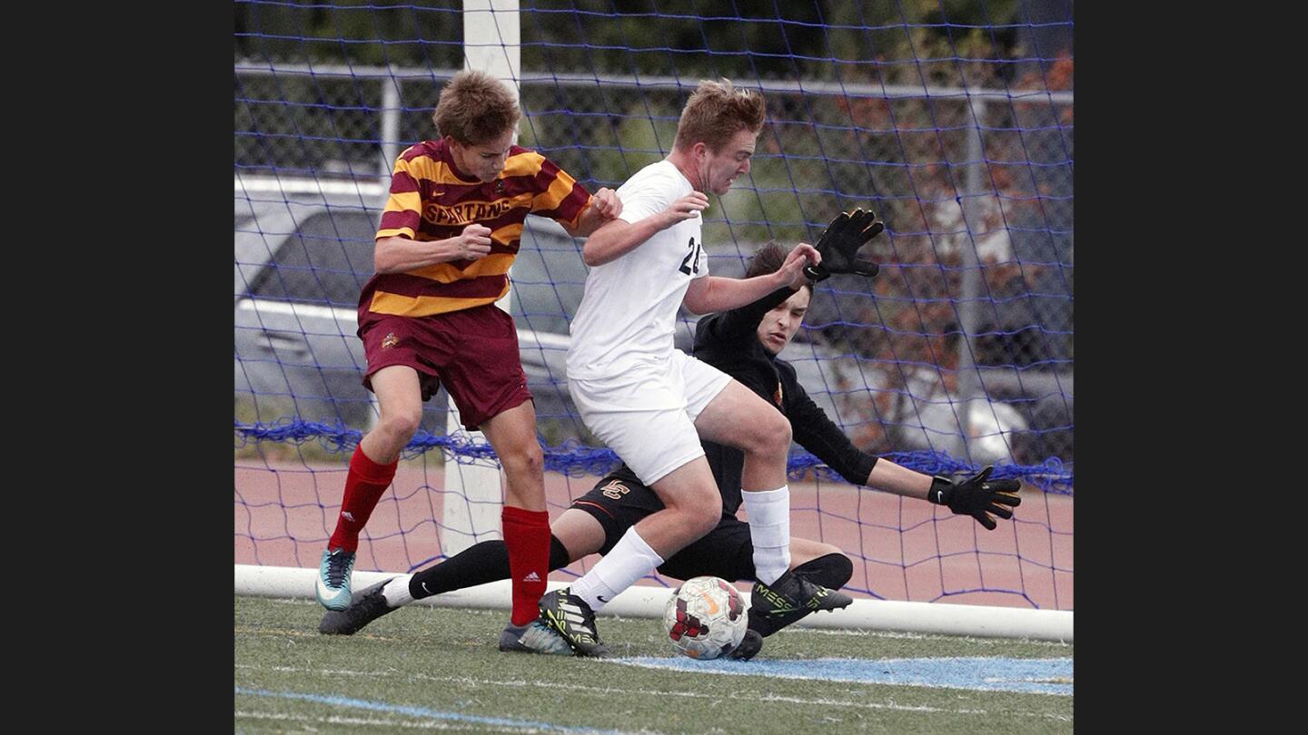 A battle in front of the La Canada goal between La Canada's goalie Jorge Landa and teammate Daniel Landesman against Crescenta Valley's Zander Bakunowski who is trying to score in a nonleague boys soccer game at Crescenta Valley High School on Wednesday, December 20, 2017. The game ended in a 1-1 tie.