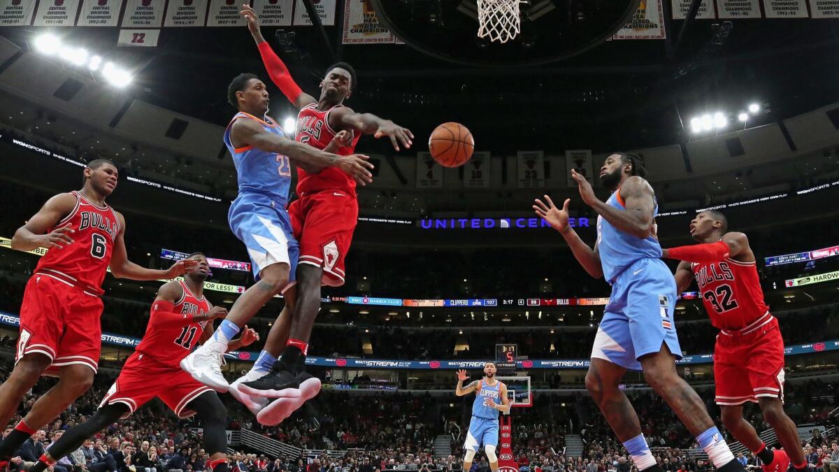 The Clippers' Lou Williams passes around Chicago's Bobby Portis to DeAndre Jordan on March 13.