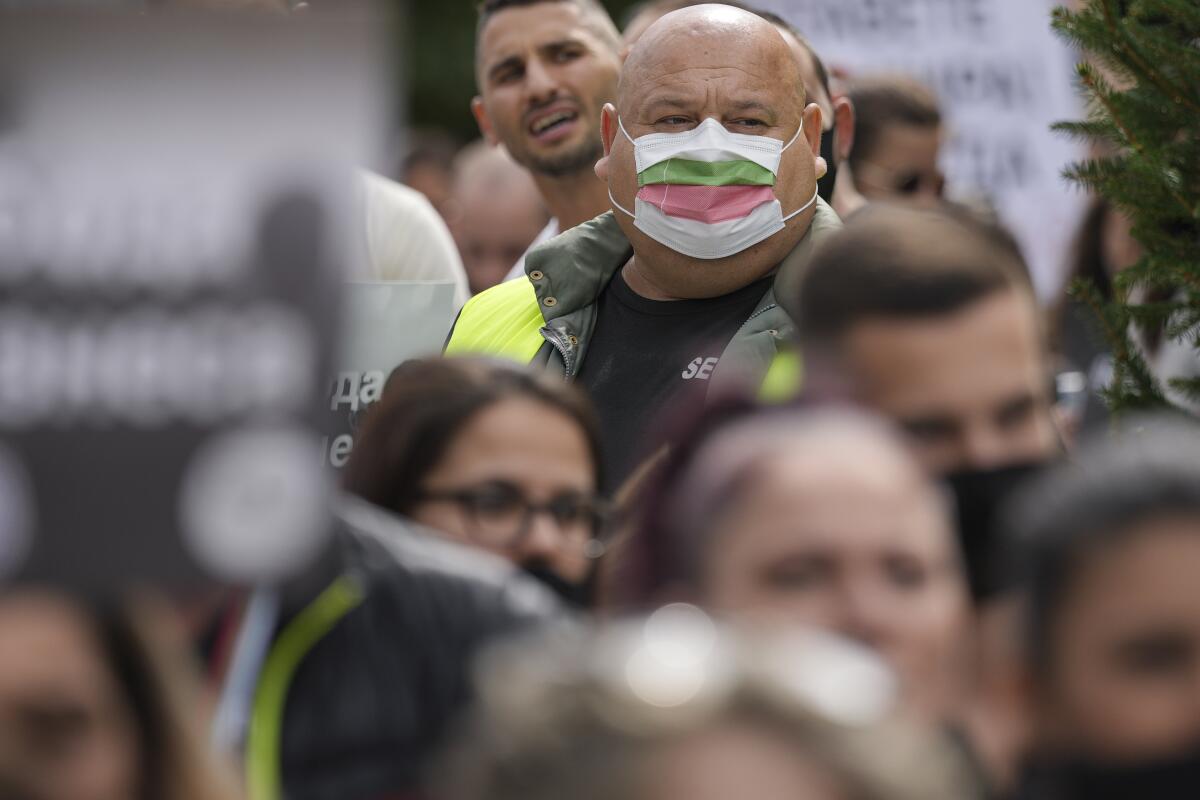 A man wears a mask in the colors of the Bulgarian flag while attending a protest by restaurant workers in Veliko Tarnovo, Bulgaria, Thursday, Sept. 2, 2021. Since the start of the pandemic, more than 19,000 people in Bulgaria have died of COVID-19, a grim statistic that makes the country's death rate from the disease the EU's third-highest behind only the Czech Republic, and Hungary. (AP Photo/Vadim Ghirda)