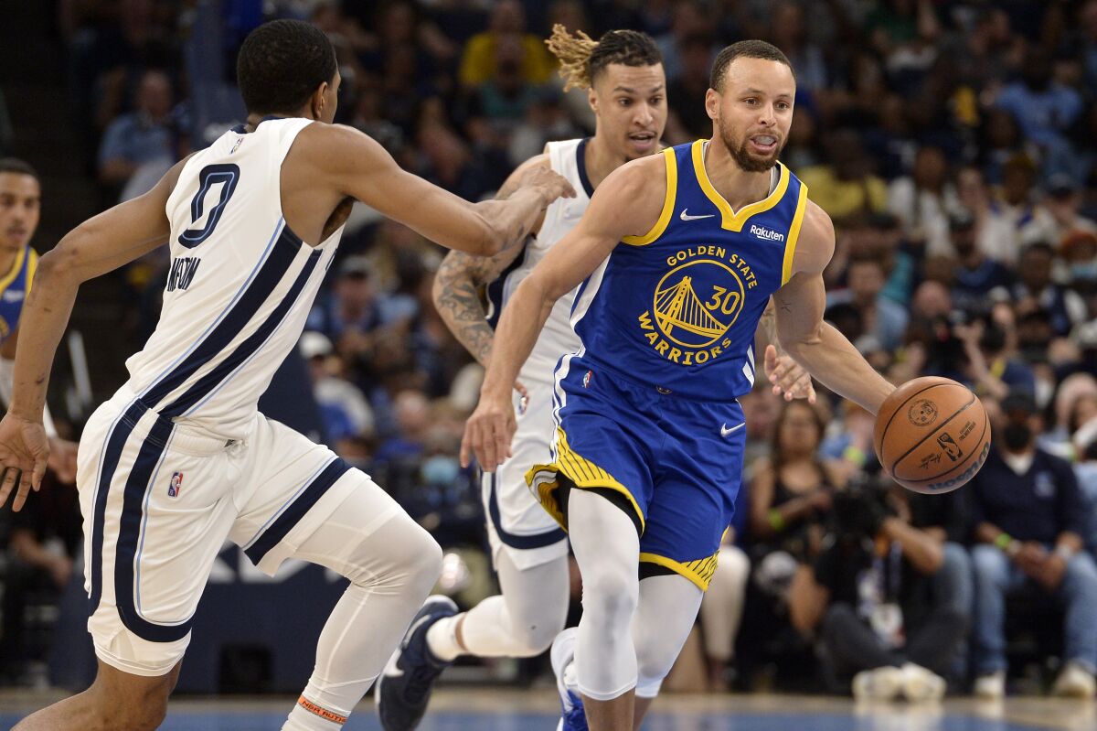 Golden State Warriors guard Stephen Curry (30) brings the ball upcourt ahead of Memphis Grizzlies forward Brandon Clarke, back right, in the second half during Game 1 of a second-round NBA basketball playoff series Sunday, May 1, 2022, in Memphis, Tenn. (AP Photo/Brandon Dill)