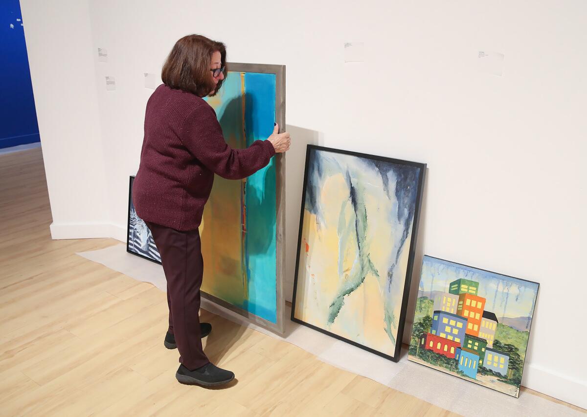 Kate Hoffman, executive director of the Huntington Beach Art Center, sorts through pieces at the center this week.