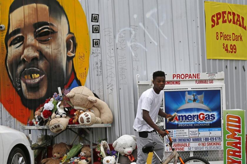 FILE - In this June 27, 2017 photo, Ronald Smith gets on his bicycle after stopping at the Triple S Food Mart, where Alton Sterling was shot by police one year ago, in Baton Rouge, La. Louisiana's attorney general plans to meet Tuesday, March 27, 2018, with relatives of Sterling, a black man who was shot and killed by a white Baton Rouge police officer, to inform them whether his office will charge either of the two officers involved in the deadly struggle, according to two family lawyers. (AP Photo/Gerald Herbert, File)