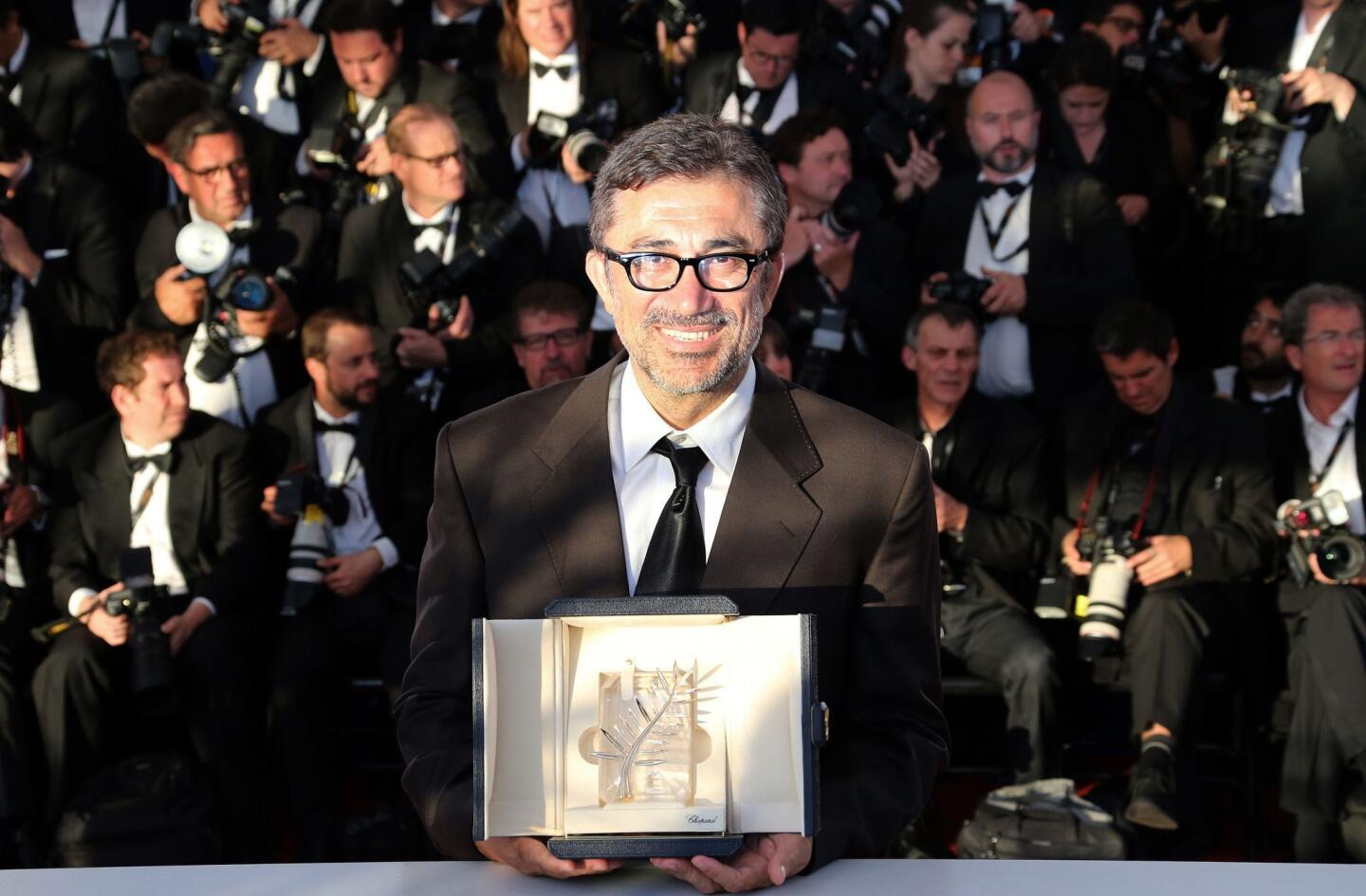 Turkish director Nuri Bilge Ceylan poses with the Palme d'Or for the film "Winter Sleep" after the closing ceremony of the Cannes Film Festival.
