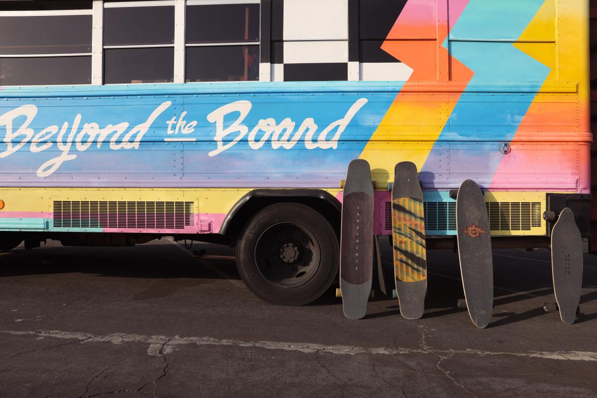 Skateboards are lined up along a "Beyond the Board" bus.