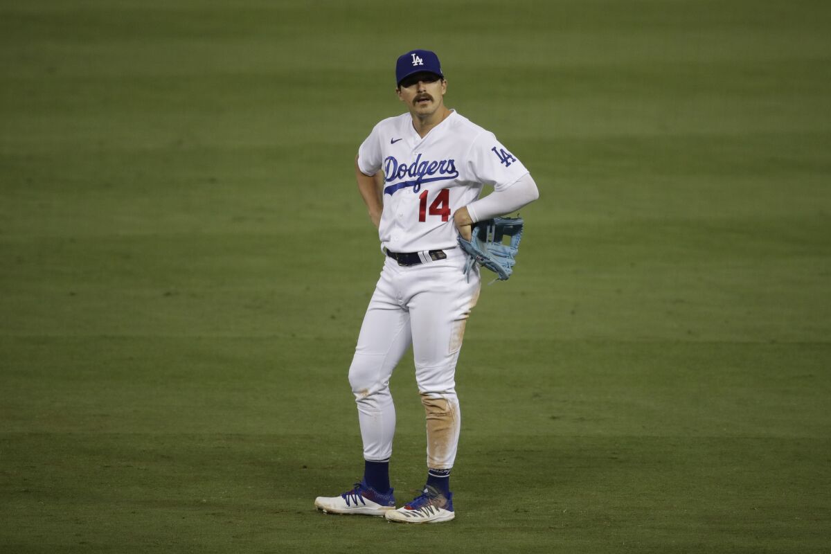 Kiké Hernández of the Los Angeles Dodgers stands on the field with his hands on his hips.