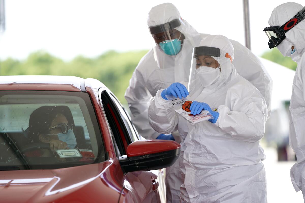 Registered nurse April Lewis prepares to administer a test at a COVID-19 drive-through testing site in Houston.