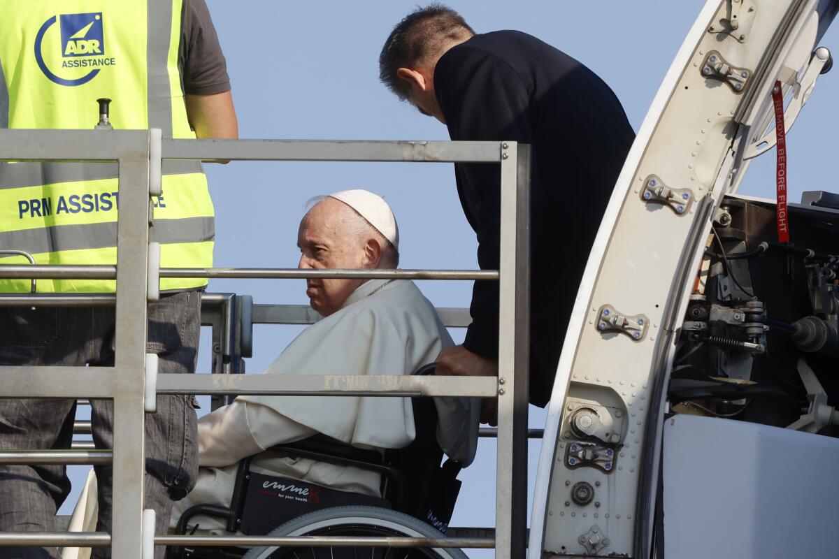 Pope Francis sits in a wheelchair.