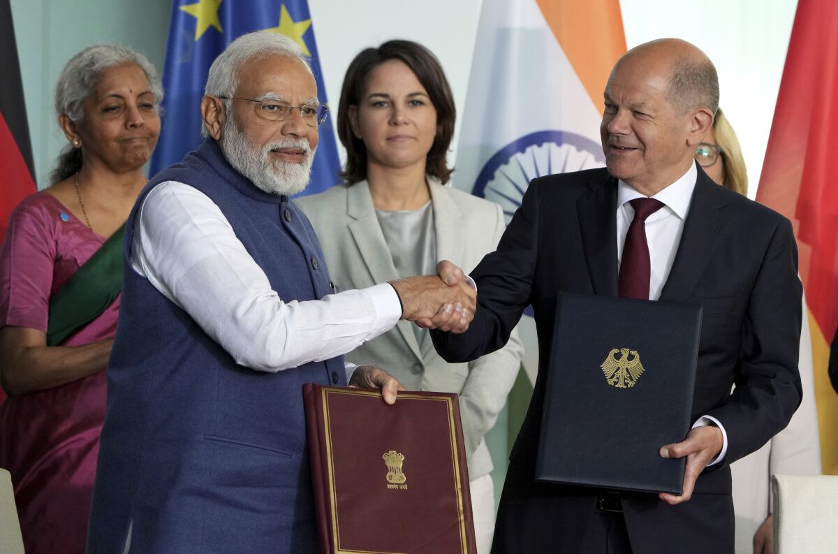 German Chancellor Olaf Scholz, right, and Indian Prime Minister Narendra Modi, left, shake hands after contract signing ceremony as part of a meeting at the chancellery in Berlin, Germany, Monday, May 2, 2022. (AP Photo/Michael Sohn)