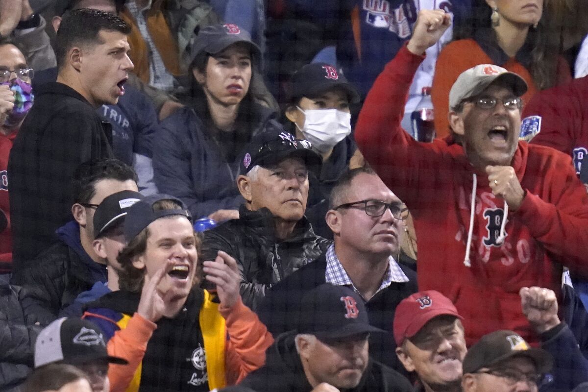 Former New York Yankees Bucky Dent (middle in Yankees cap) watches as Boston Red Sox fans cheer after Yankees' Brett Gardner struck out in the seventh inning of the American League Wild Card playoff game against the Boston Red Sox at Fenway Park, Tuesday Oct. 5, 2021 in Boston. (AP Photo/Charles Krupa)