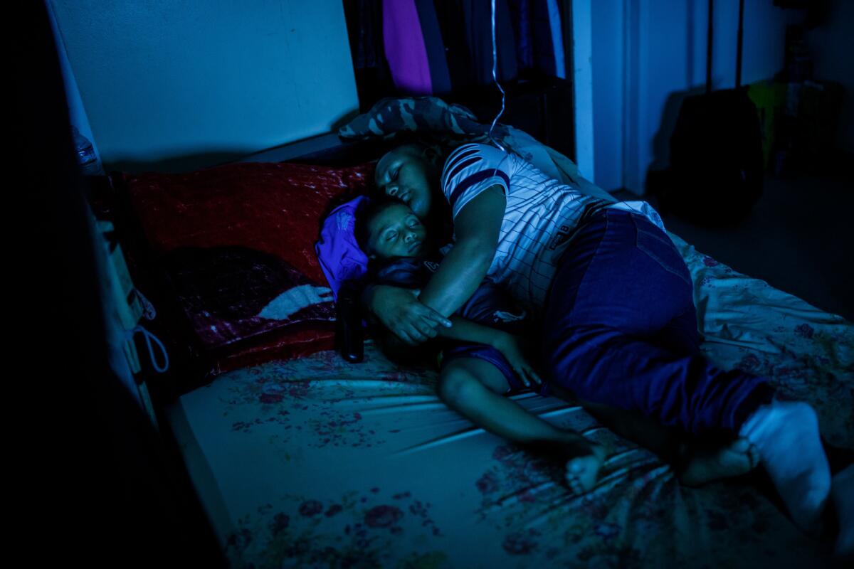 Hermelindo Che Coc falls asleep watching television with his 6-year-old son Jefferson Che Pop after they arrived home from LAX. (Marcus Yam / Los Angeles Times)