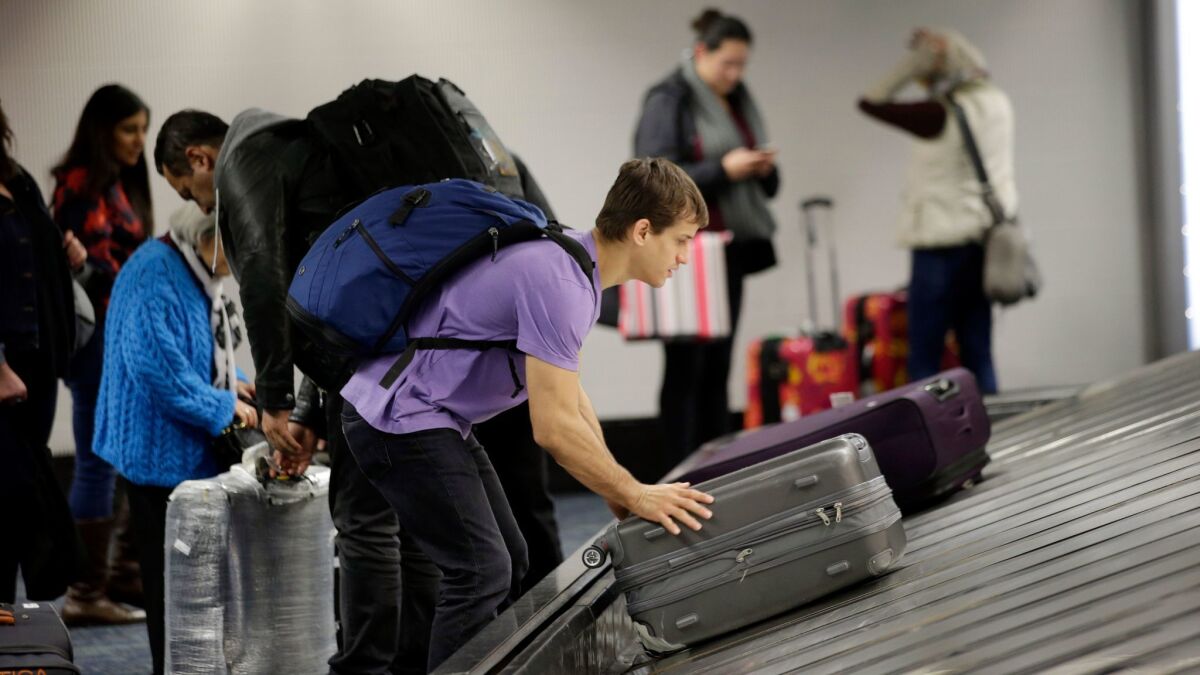 A traveler gathers his luggage at the San Francisco International Airport. American Airlines has launched a program that alerts travelers when their bags don't arrive at the same airport.