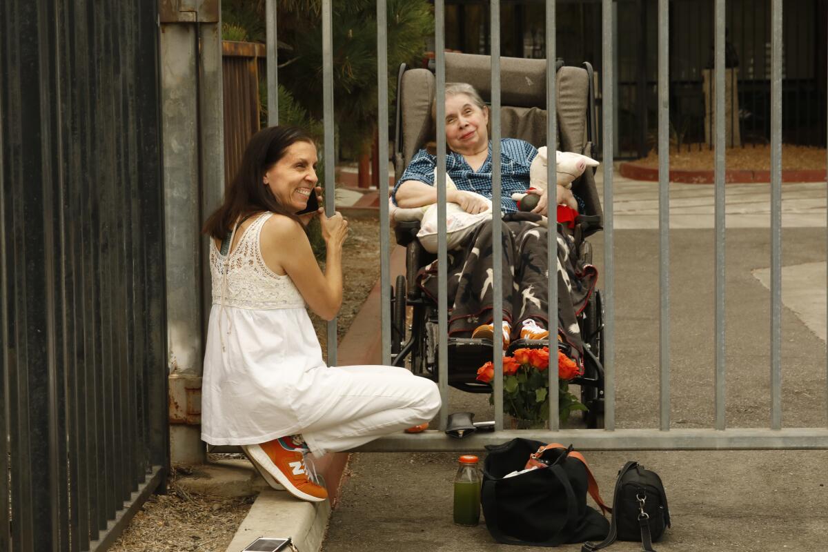 La fotógrafa y escritora Hannah Kozak visita a su madre, Rachel Dietsch, en la puerta del hogar de ancianos donde vive.