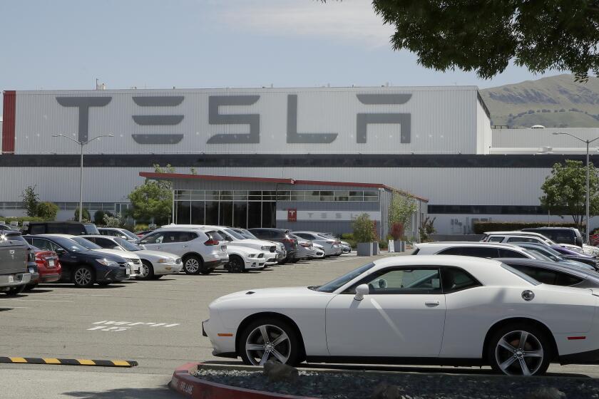 Vehicles are seen parked at the Tesla car plant Monday, May 11, 2020, in Fremont, Calif. 