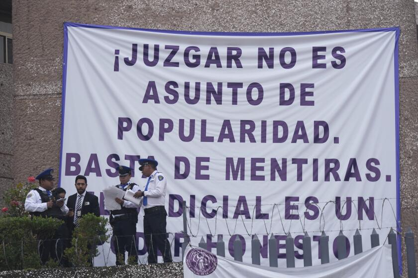 Personal de seguridad labora en un tribunal mientras trabajadores judiciales sindicalizados se reúnen en el exterior para declararse en huelga contra una propuesta gubernamental de reforma, la cual haría que todos los jueces sean sujetos de elección popular, el lunes 19 de agosto de 2024, en Ciudad de México. (AP Foto/Fernando Llano)