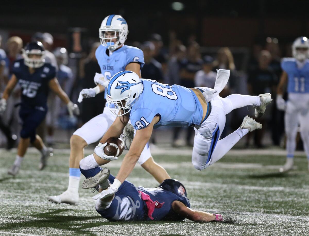 Corona del Mar's Mark Redman vaults over a Newport Harbor defender in the first half of the Battle of the Bay game on Friday at Davidson Field.