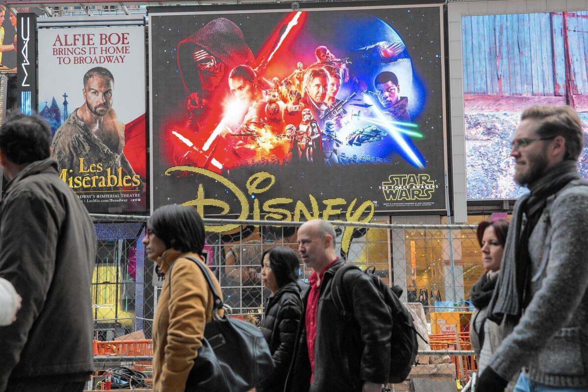 An ad for "Star Wars: The Force Awakens" hangs in New York's Times Square. The film, which opens Friday, is expected to earn $1.5 billion to $2 billion in global box-office returns.