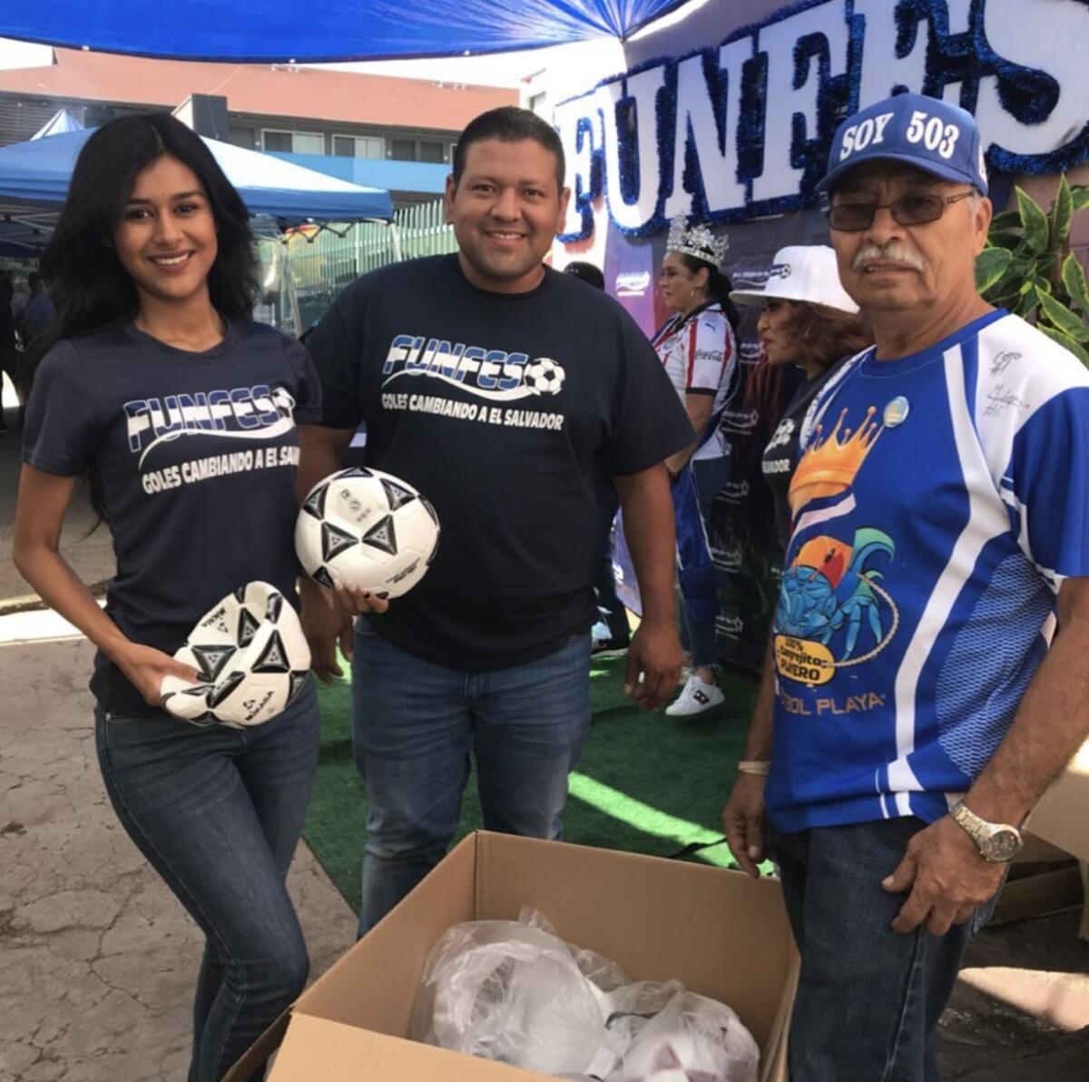 Voluntarios e integrantes de la Fundación Fútbol por El Salvador reciben balones para enviarlos a programas deportivos.