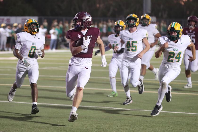 Redmond Chesley (0) of Laguna Beach, steps into the endzone for a touchdown after 15-yard run leaving empty handed defenders behind him during nonleague football game against Kennedy on Friday at Laguna Beach High School.