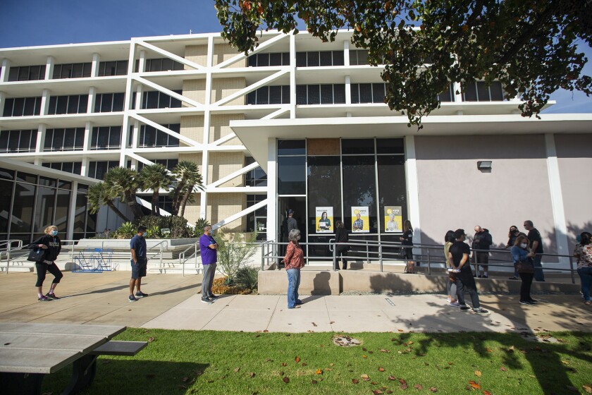 Voters wait in line to cast their ballots at the Costa Mesa City Hall voting center.