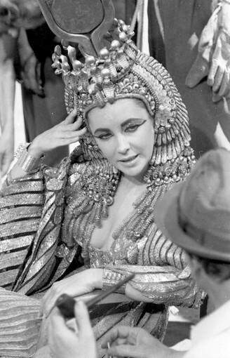 Elizabeth Taylor's on the film set of "Cleopatra" in Rome in 1962. Vittorio Nino Novarese and Renie made Taylor's gilded costumes for the historical epic. Taylor did her own makeup. In June, Profiles in History will auction the elaborate headdress Taylor wore in the film.