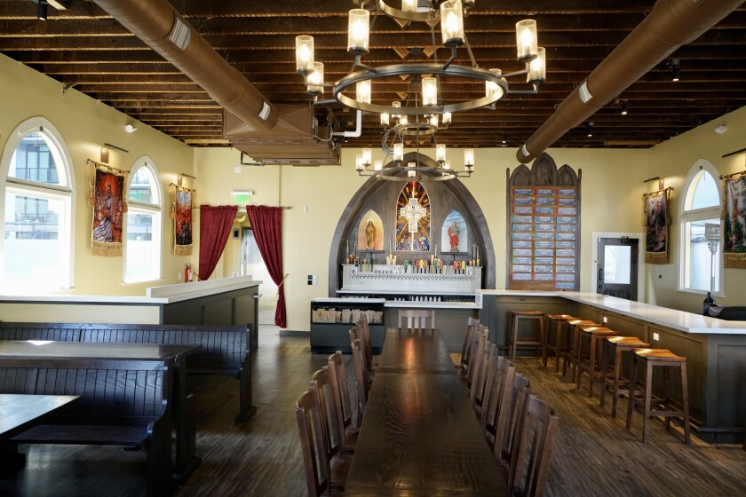 The Church by The Lost Abbey features arched windows, chandeliers and dark wood accents.