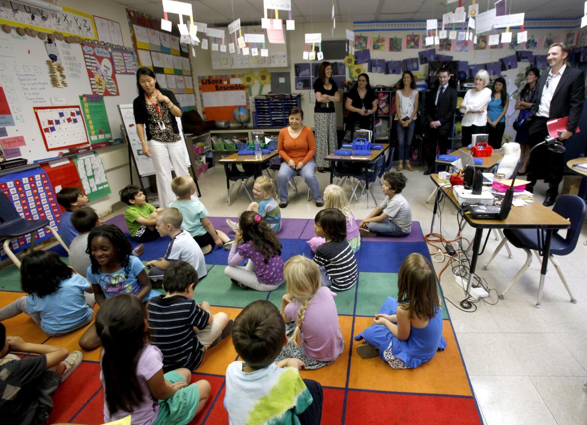 French dignitaries, including Senator Claudine LePage, visited the French immersion Kindergarten class, taught by Valerie Sun, standing next to children, at Franklin Magnet Elementary School in Glendale in May 2013.