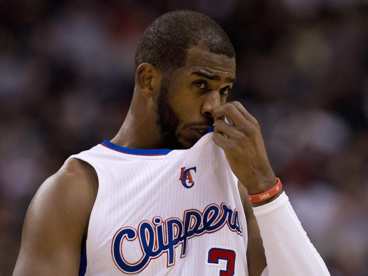 Clippers point guard Chris Paul wipes away sweat as he looks on during the first half of a loss at Toronto.