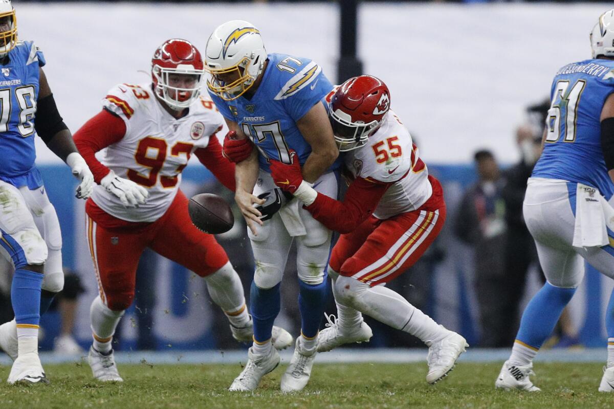 Chargers quarterback Philip Rivers is sacked by the Chiefs' Frank Clark (55) and  Joey Ivie (93), and loses the football. L.A. recovered the fumble.