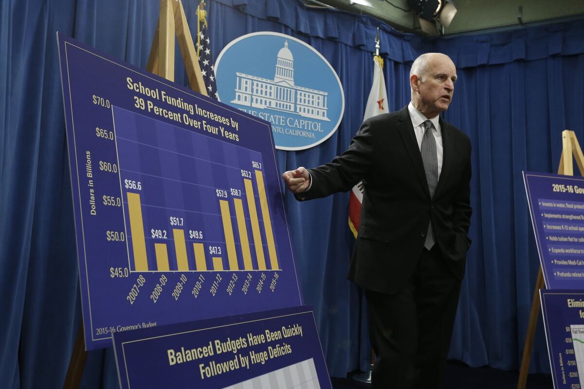 Gov. Jerry Brown gestures to a chart showing the increase in school funding in the past four years at a news conference in Sacramento on Jan. 9.