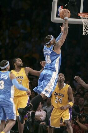 The Nuggets' Carmelo Anthony flies through the lane for a layup between Ronny Turiaf and Kobe Bryant.