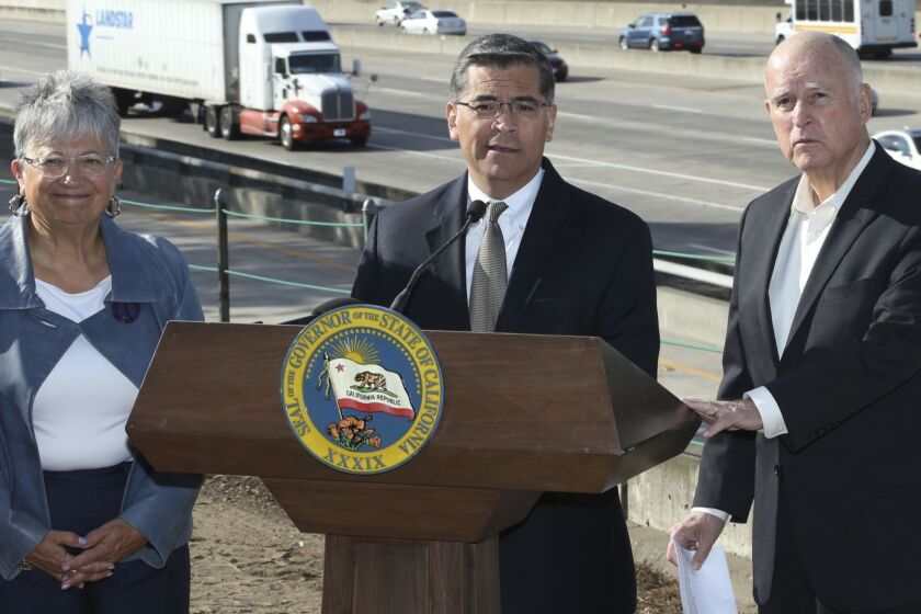 FILE - In this Oct. 26, 2018 file photo, California Attorney General Xavier Becerra, center, discusses a Trump administration plan to freeze vehicle emissions standards during a news conference in Sacramento, Calif. Becerra was joined by California Air Resources Board Chairperson Mary Nichols, and Gov. Jerry Brown. Becerra immediately became perhaps the nations most influential attorney general when he was named Californias top lawyer two years ago. (AP Photo/Rich Pedroncelli, File)
