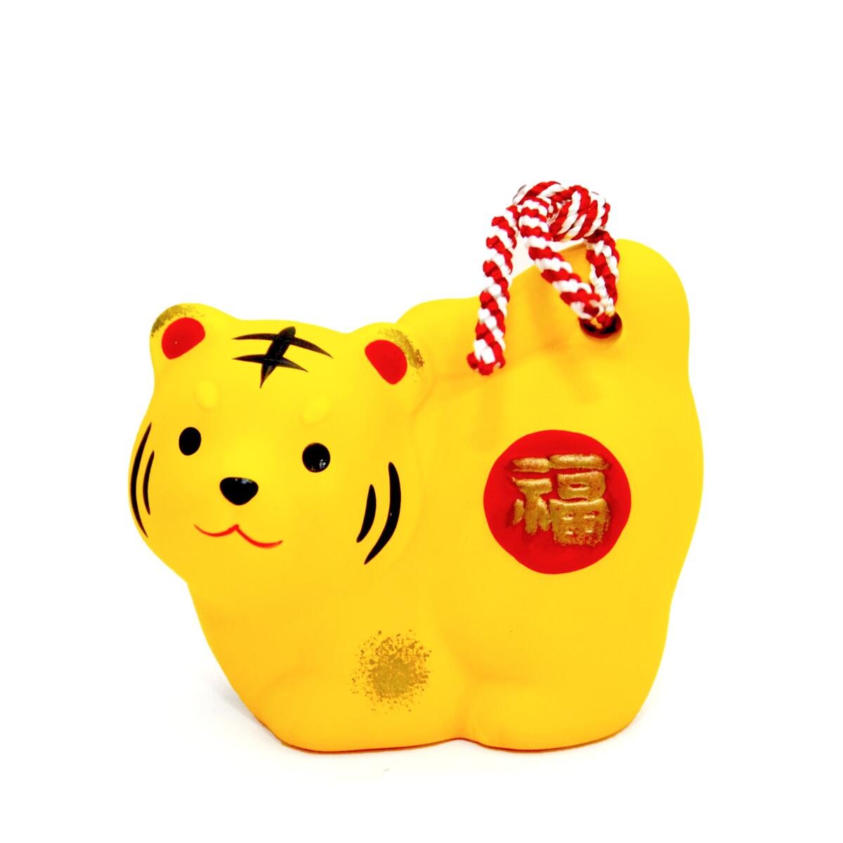 Un adorno de campana amarilla con forma de tigre