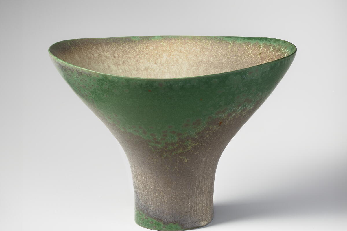 A clay vase glazed green.