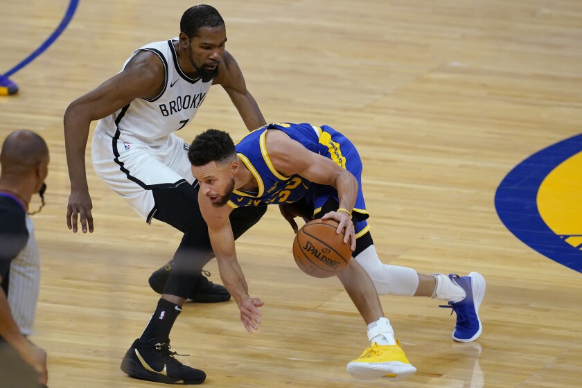 Golden State Warriors guard Stephen Curry, right, is defended by Brooklyn Nets forward Kevin Durant during the first half of an NBA basketball game in San Francisco, Saturday, Feb. 13, 2021. (AP Photo/Jeff Chiu)