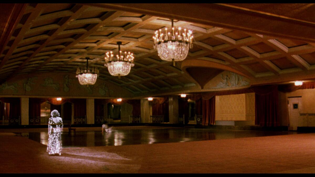 A ghostly figure of a woman walks through an empty Ambassador Hotel ballroom.