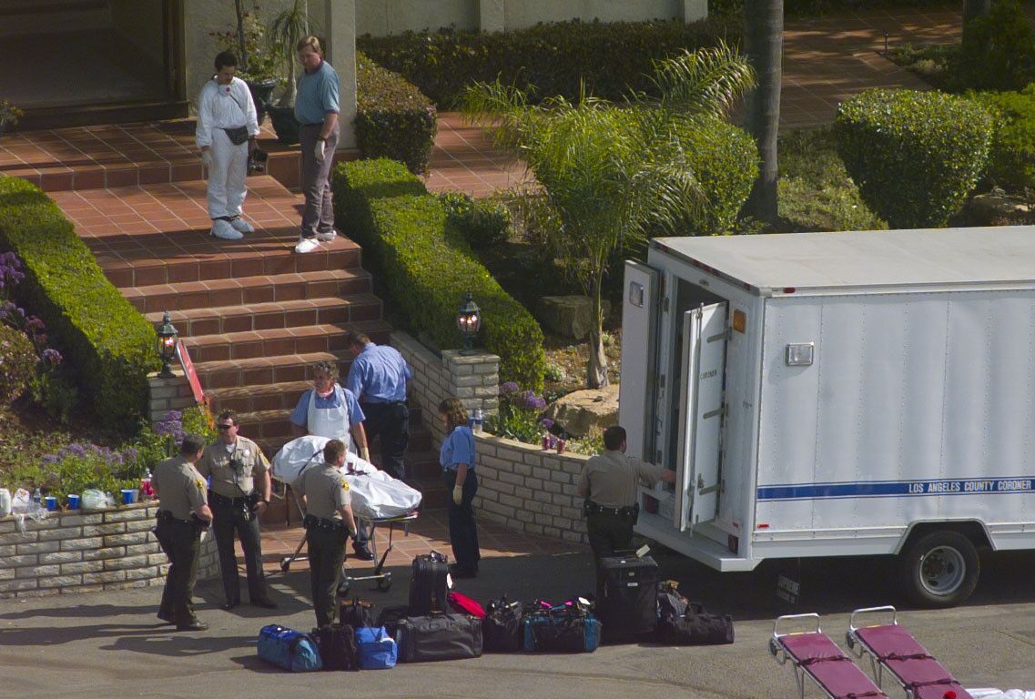 County medical examiner workers and sheriff's deputies bring down the steps of a Rancho Santa Fe mansion the body of a Heaven's Gate member. The bodies of 39 Heaven's Gate members were discovered inside the home on March 26, 1997. They died in a mass suicide.