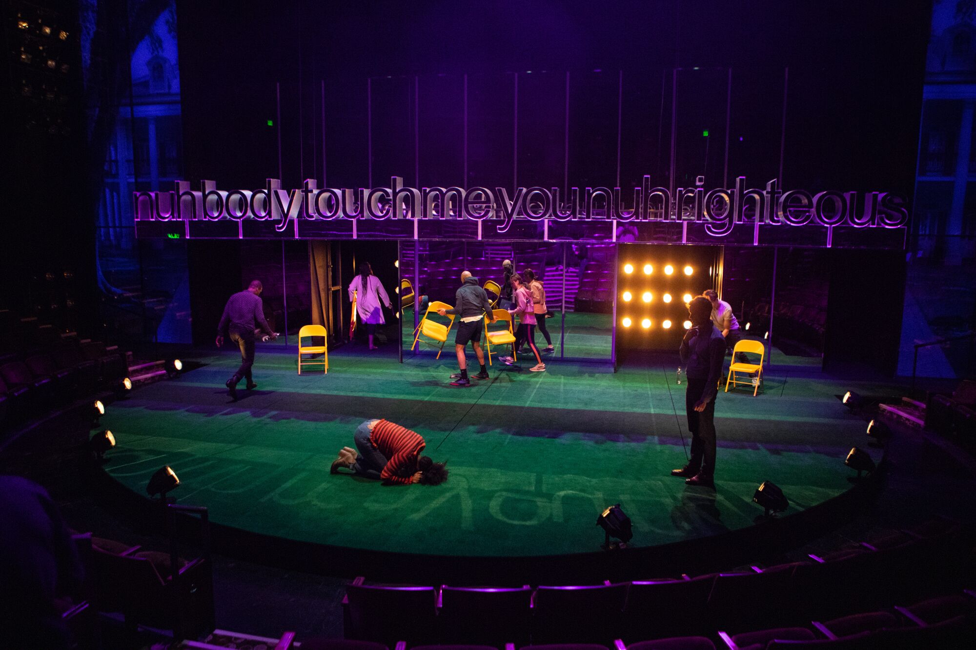 Actors perform within a semicircle of footlights.